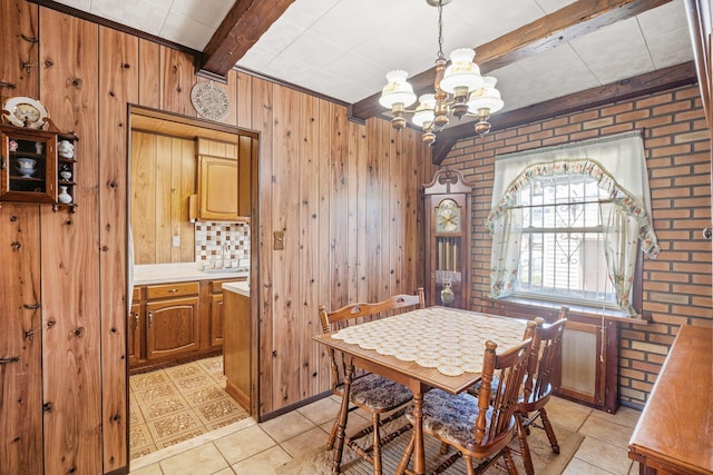 2010 27th St, Astoria, NY 11105 - dining area featuring a chandelier, beam ceiling, wood walls, light tile patterned floors, and brick wall