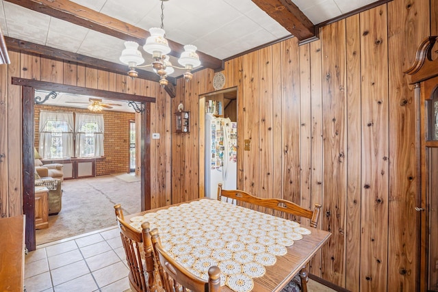 2010 27th St, Astoria, NY 11105 - dining room with light carpet, wood walls, a chandelier, beam ceiling, and light tile patterned floors