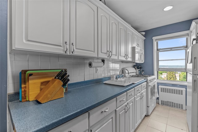 60 Locust Ave Unit 610, New Rochelle, NY 10801 - kitchen featuring radiator, white appliances, white cabinets, dark countertops, and recessed lighting