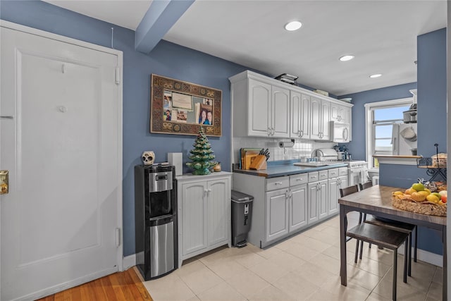 60 Locust Ave Unit 610, New Rochelle, NY 10801 - kitchen with white microwave, stove, recessed lighting, white cabinets, and a sink