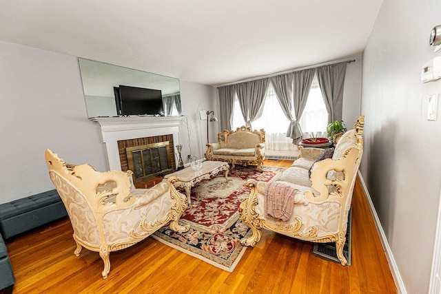 426 N High St, Mount Vernon, NY 10552 - living area with wood finished floors, a brick fireplace, and baseboards
