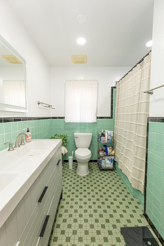 426 N High St, Mount Vernon, NY 10552 - bathroom with tile walls, double vanity, toilet, tile patterned floors, and wainscoting