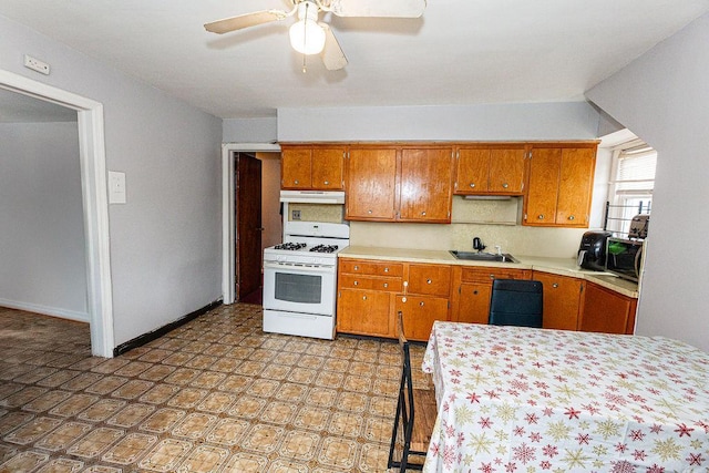 426 N High St, Mount Vernon, NY 10552 - kitchen featuring white gas stove, under cabinet range hood, brown cabinets, light countertops, and a ceiling fan
