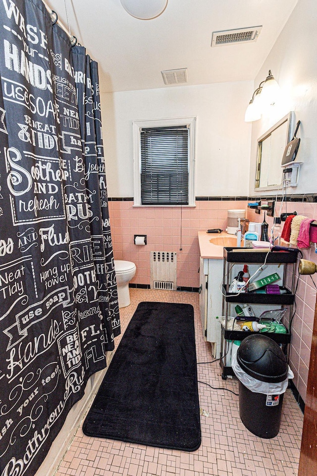 426 N High St, Mount Vernon, NY 10552 - bathroom with radiator heating unit, tile walls, wainscoting, toilet, and vanity