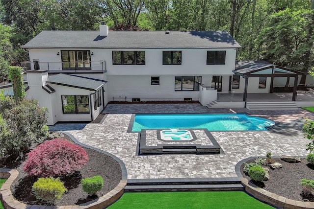 38 Cottontail Rd, Melville, NY 11747 - back of house with a balcony, a chimney, a patio area, an outdoor pool, and a shingled roof