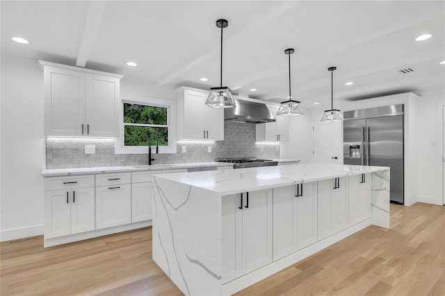 38 Cottontail Rd, Melville, NY 11747 - kitchen with built in refrigerator, light wood finished floors, wall chimney exhaust hood, a large island, and recessed lighting