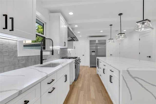 38 Cottontail Rd, Melville, NY 11747 - kitchen with high end appliances, wall chimney range hood, a sink, light wood finished floors, and tasteful backsplash
