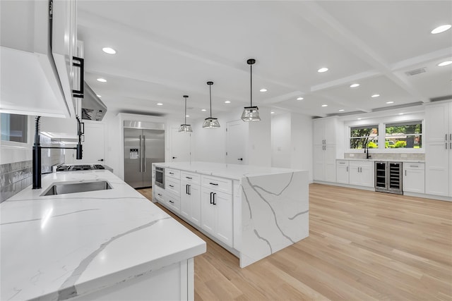 38 Cottontail Rd, Melville, NY 11747 - kitchen featuring beverage cooler, stainless steel built in fridge, backsplash, light wood-style flooring, and a kitchen island