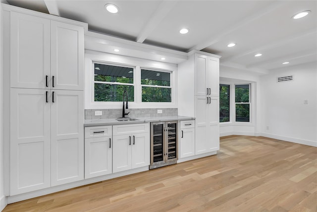 38 Cottontail Rd, Melville, NY 11747 - indoor bar with beverage cooler, light wood-type flooring, baseboards, decorative backsplash, and healthy amount of natural light