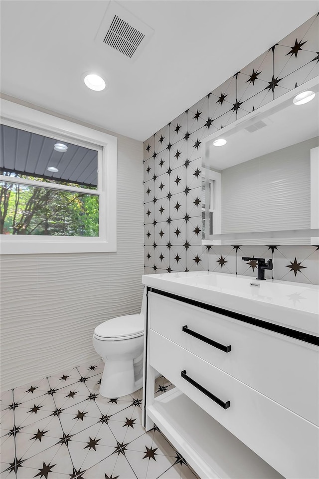 38 Cottontail Rd, Melville, NY 11747 - half bathroom featuring vanity, toilet, and tile walls