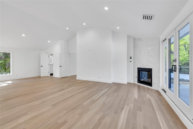 38 Cottontail Rd, Melville, NY 11747 - unfurnished living room featuring healthy amount of natural light, light wood-type flooring, a premium fireplace, lofted ceiling, and recessed lighting