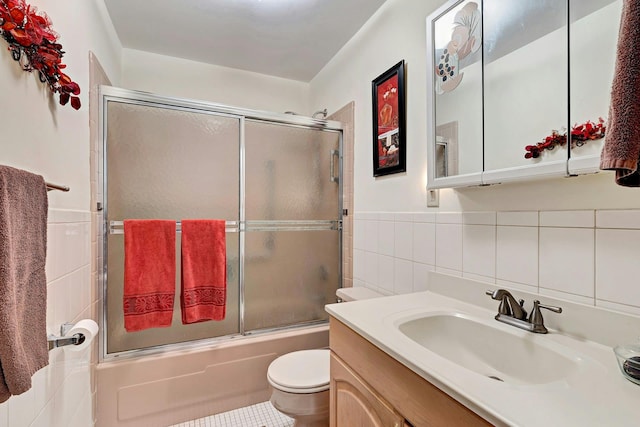 192 Ventry Ct Unit A, Ridge, NY 11961 - full bathroom featuring tile walls, toilet, vanity, bath / shower combo with glass door, and wainscoting