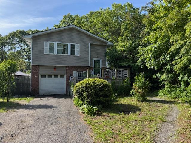 2572 Motor Pkwy, Ronkonkoma, NY 11779 - tri-level home featuring a garage, asphalt driveway, and brick siding