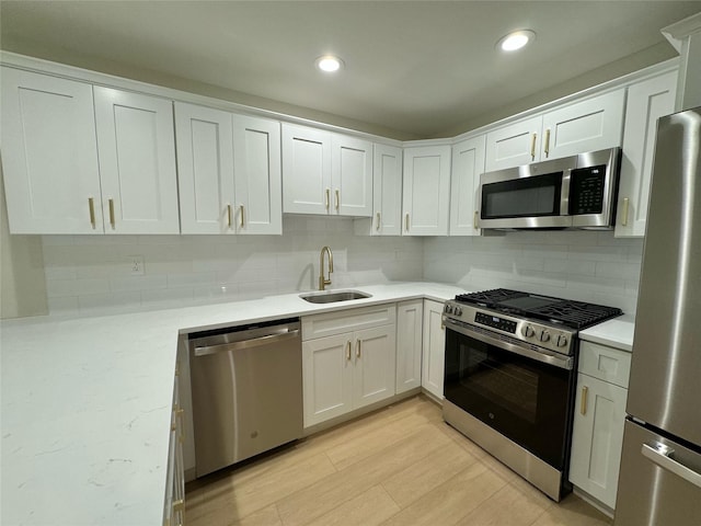 19 Erin Ln, East Setauket, NY 11733 - kitchen with appliances with stainless steel finishes, a sink, backsplash, white cabinets, and recessed lighting