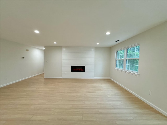 19 Erin Ln, East Setauket, NY 11733 - unfurnished living room with light wood-style floors, baseboards, a fireplace, and recessed lighting