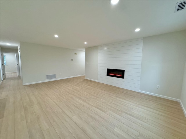 19 Erin Ln, East Setauket, NY 11733 - unfurnished living room with a large fireplace, light wood-style floors, baseboards, and recessed lighting