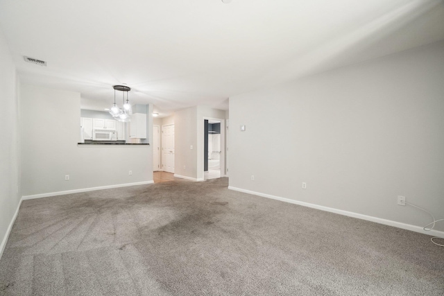 200 Woodcrest Ln Unit 202, Mount Kisco, NY 10549 - unfurnished living room featuring a chandelier, carpet floors, and baseboards