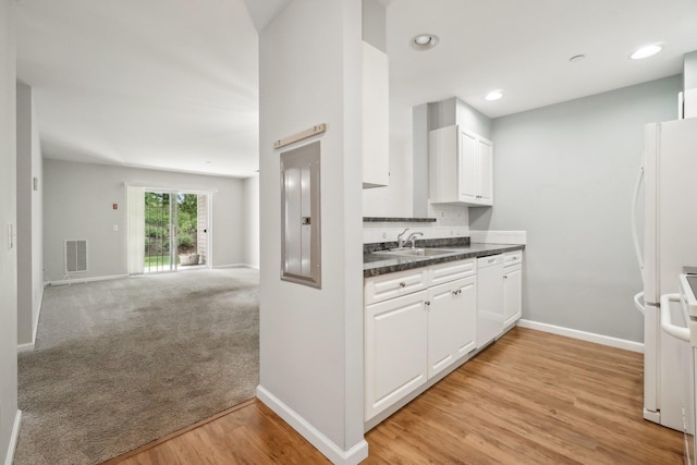 200 Woodcrest Ln Unit 202, Mount Kisco, NY 10549 - kitchen with dark countertops, open floor plan, a sink, white cabinetry, and baseboards