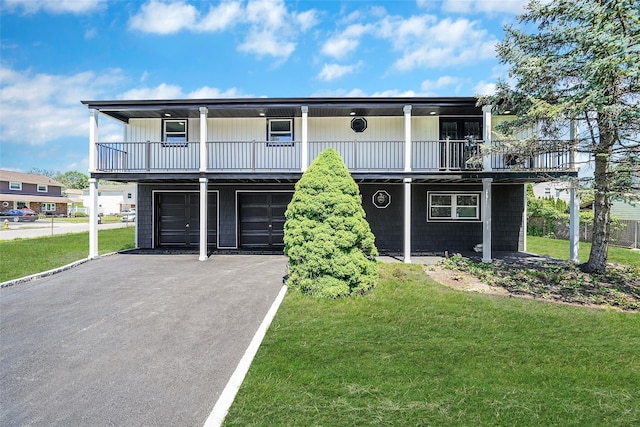 71 Cinnamon St, Central Islip, NY 11722 - view of front of home with driveway, a front lawn, an attached garage, and a balcony