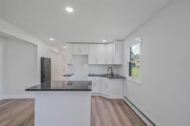 71 Cinnamon St, Central Islip, NY 11722 - kitchen with freestanding refrigerator, a sink, a baseboard heating unit, light wood-style flooring, and recessed lighting