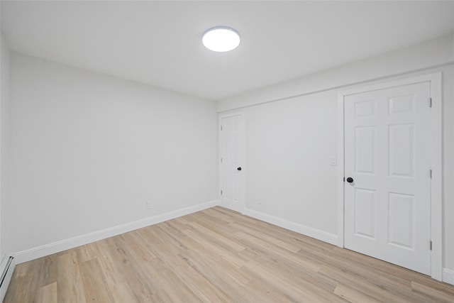 71 Cinnamon St, Central Islip, NY 11722 - unfurnished bedroom featuring light wood-style flooring, baseboards, a closet, and baseboard heating