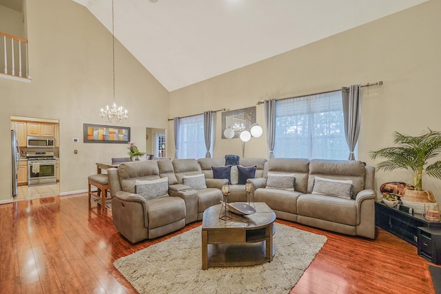 15 Arielle Ct, Hauppauge, NY 11749 - living room featuring a chandelier, high vaulted ceiling, light wood-style flooring, and baseboards