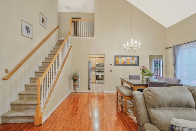 15 Arielle Ct, Hauppauge, NY 11749 - dining space with a towering ceiling, a chandelier, light wood-style flooring, stairs, and baseboards