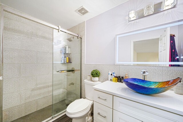 15 Arielle Ct, Hauppauge, NY 11749 - full bathroom featuring vanity, toilet, a stall shower, and tile walls