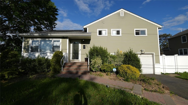821 Virginia Ave, North Bellmore, NY 11710 - tri-level home featuring a garage, asphalt driveway, and solar panels