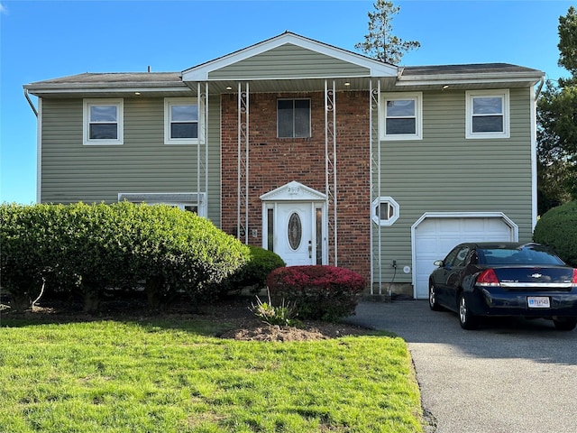 20 Sunshine Ln, Amityville, NY 11701 - view of front of house with an attached garage, driveway, a front yard, and brick siding