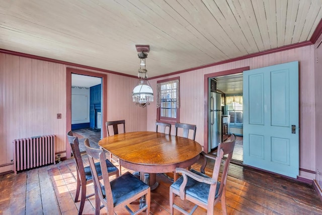 201 E Broadway Prt, Jefferson, NY 11777 - dining space with radiator heating unit, ornamental molding, dark wood-style flooring, wood walls, and a chandelier