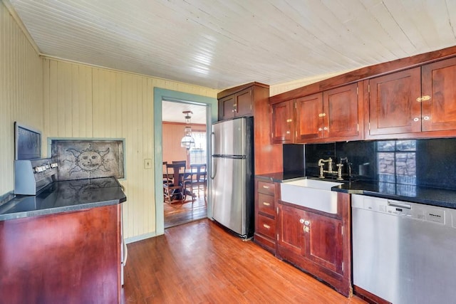 201 E Broadway Prt, Jefferson, NY 11777 - kitchen featuring appliances with stainless steel finishes, a sink, dark countertops, decorative backsplash, and wood finished floors