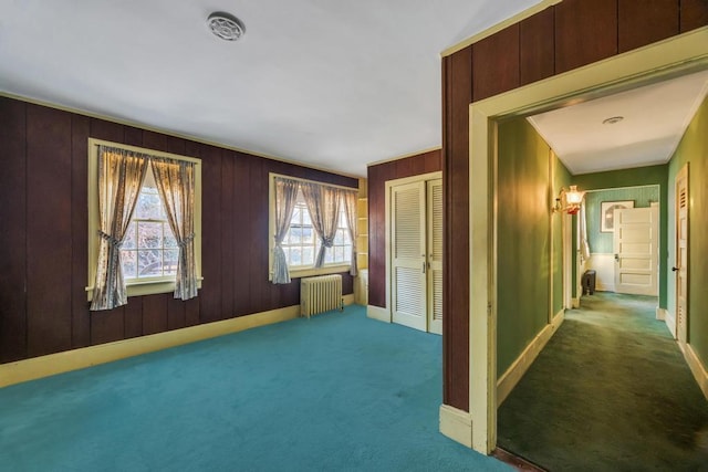 201 E Broadway Prt, Jefferson, NY 11777 - hallway featuring radiator, carpet floors, baseboards, and wooden walls