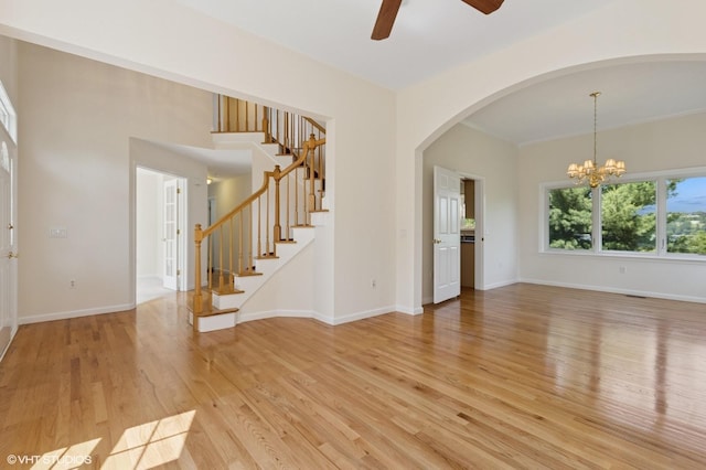 195 Old Castle Point Rd, Wappingers Falls, NY 12590 - unfurnished living room with light wood-style floors, a ceiling fan, stairs, a chandelier, and arched walkways