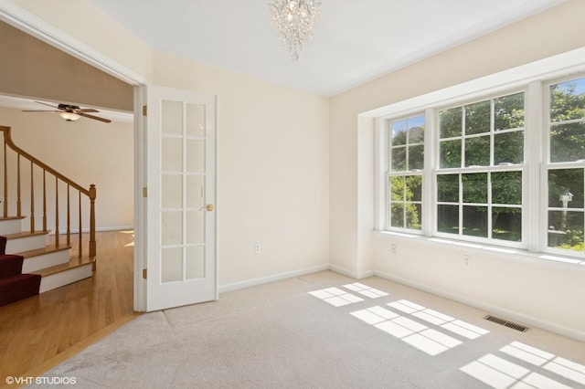195 Old Castle Point Rd, Wappingers Falls, NY 12590 - carpeted empty room featuring healthy amount of natural light, stairway, a chandelier, and baseboards