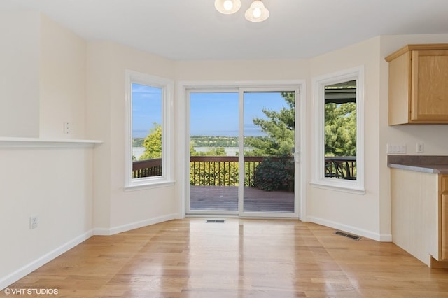 195 Old Castle Point Rd, Wappingers Falls, NY 12590 - unfurnished dining area with light wood finished floors, baseboards, and a chandelier