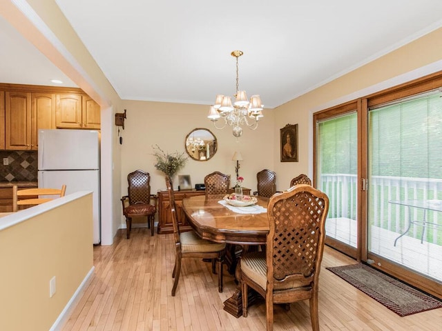 143 Flintlock Way Unit D, Yorktown Heights, NY 10598 - dining room featuring light wood finished floors, a chandelier, ornamental molding, and baseboards