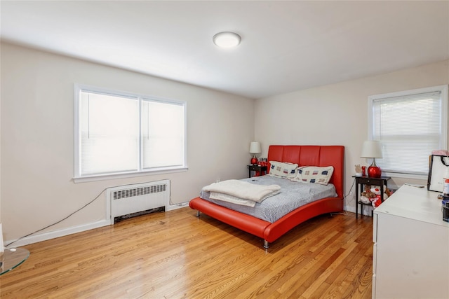 55 Nassau Ave, Glen Cove, NY 11542 - bedroom with radiator heating unit, light wood-type flooring, and baseboards
