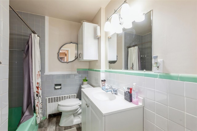 55 Nassau Ave, Glen Cove, NY 11542 - bathroom with radiator, tile walls, vanity, toilet, and wood finished floors