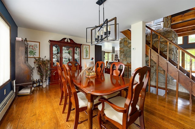 129 Clinton Corners Rd, Salt Point, NY 12578 - dining area featuring wood finished floors, stairs, a baseboard heating unit, and a chandelier