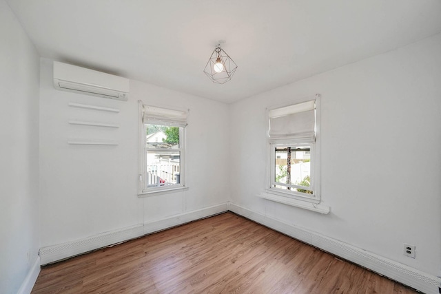 10 June Ave, Bayville, NY 11709 - empty room with an AC wall unit, wood finished floors, a baseboard radiator, and baseboards