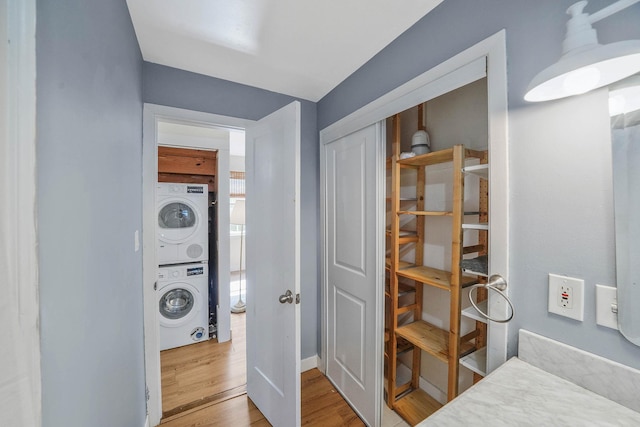 10 June Ave, Bayville, NY 11709 - washroom featuring stacked washing machine and dryer, wood finished floors, and baseboards