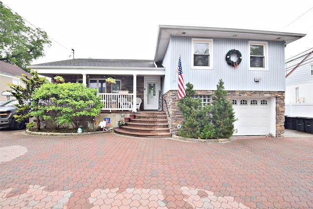 67 Hungry Harbor Rd, Valley Stream, NY 11581 - view of front of property with a porch, a garage, stone siding, and driveway