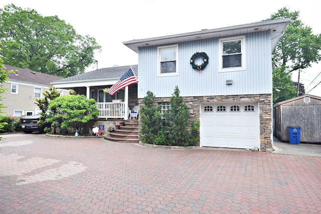 67 Hungry Harbor Rd, Valley Stream, NY 11581 - split level home with stone siding, covered porch, a garage, and decorative driveway