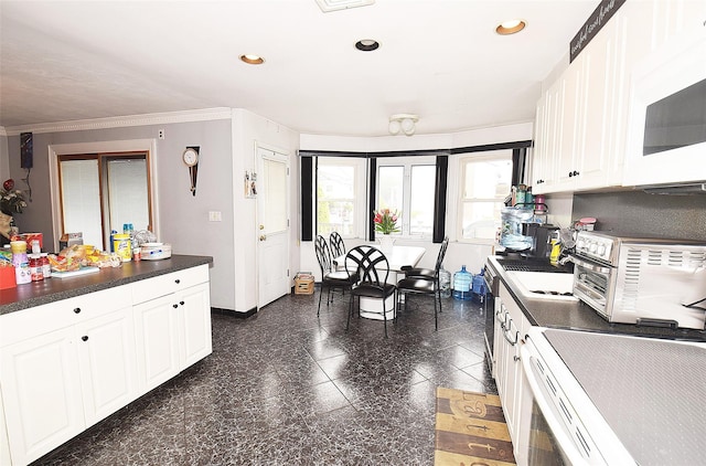 67 Hungry Harbor Rd, Valley Stream, NY 11581 - kitchen with dark countertops, ornamental molding, white microwave, white cabinetry, and recessed lighting