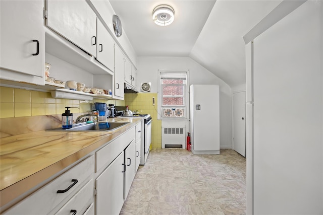 150-44 23rd Ave, Whitestone, NY 11357 - kitchen featuring gas range gas stove, radiator, under cabinet range hood, lofted ceiling, and white cabinets