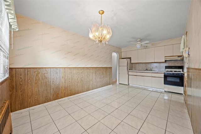 150-44 23rd Ave, Whitestone, NY 11357 - kitchen with white appliances, under cabinet range hood, a ceiling fan, wainscoting, and a chandelier