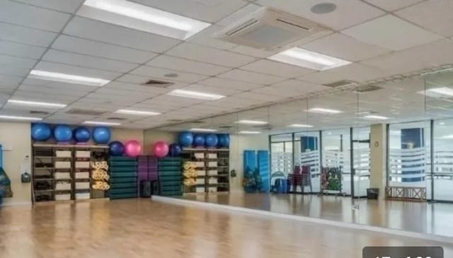 ONE Bay Club Dr Unit 18S, Bayside, NY 11360 - exercise room with wood finished floors and a paneled ceiling