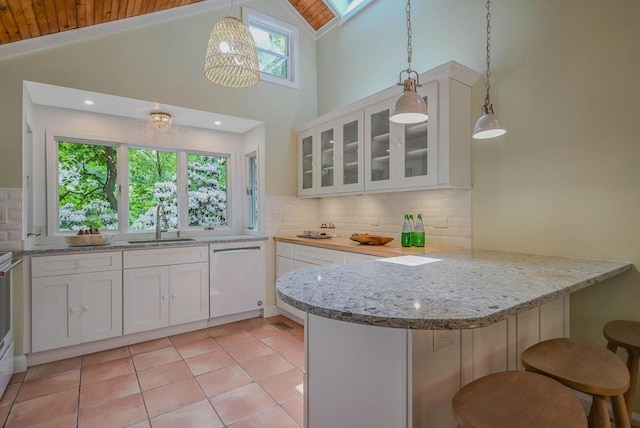 10 Maple Ave, Setauket, NY 11733 - kitchen featuring white dishwasher, a sink, wood ceiling, a peninsula, and white cabinetry