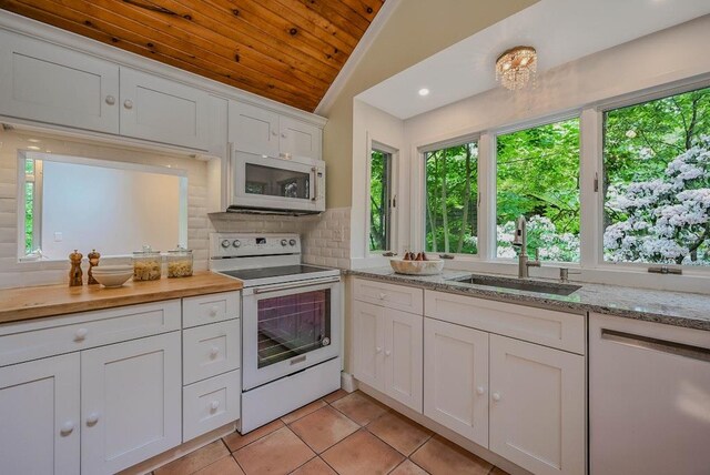 10 Maple Ave, Setauket, NY 11733 - kitchen featuring white appliances, a sink, healthy amount of natural light, vaulted ceiling, and wooden ceiling